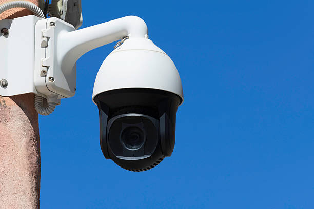 A surveillance camera outdoors that moves into different positions.